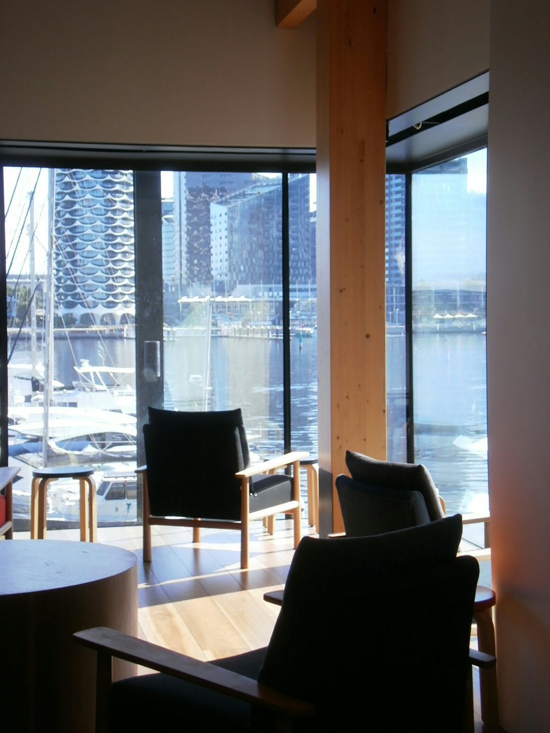 Moderna zona lounge con vista su un porto turistico con yacht bianchi ormeggiati.