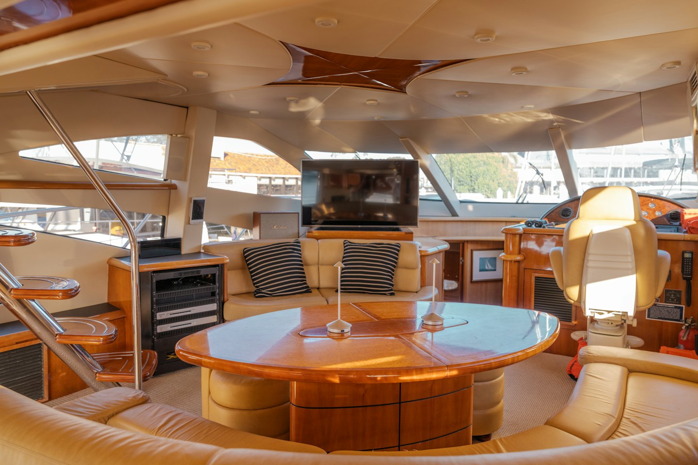 Cabina di lusso su yacht con mobili in legno e divani in pelle.