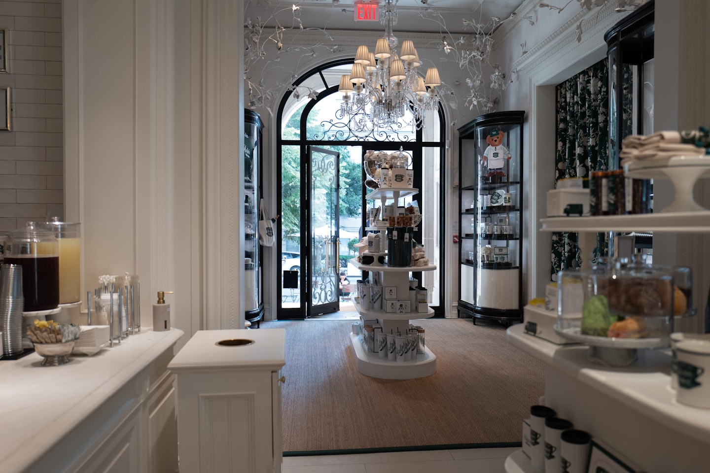 Ingresso elegante di una boutique con porta ad arco e lampadario.